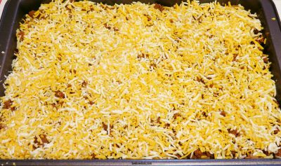 Shredded cheese layered on top of deep dish taco casserole layers