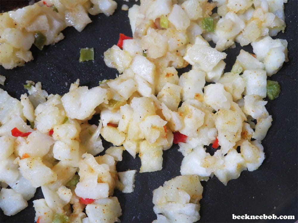 hash brown potatoes o'brien with onions and peppers in skillet
