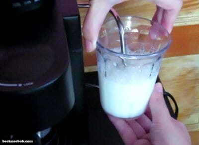 Milk being frothed under the IMUSA steam wand, with bubbles starting to form