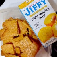 Container of honey cornbread cookies next to box of Jiffy Honey Corn Muffin Mix