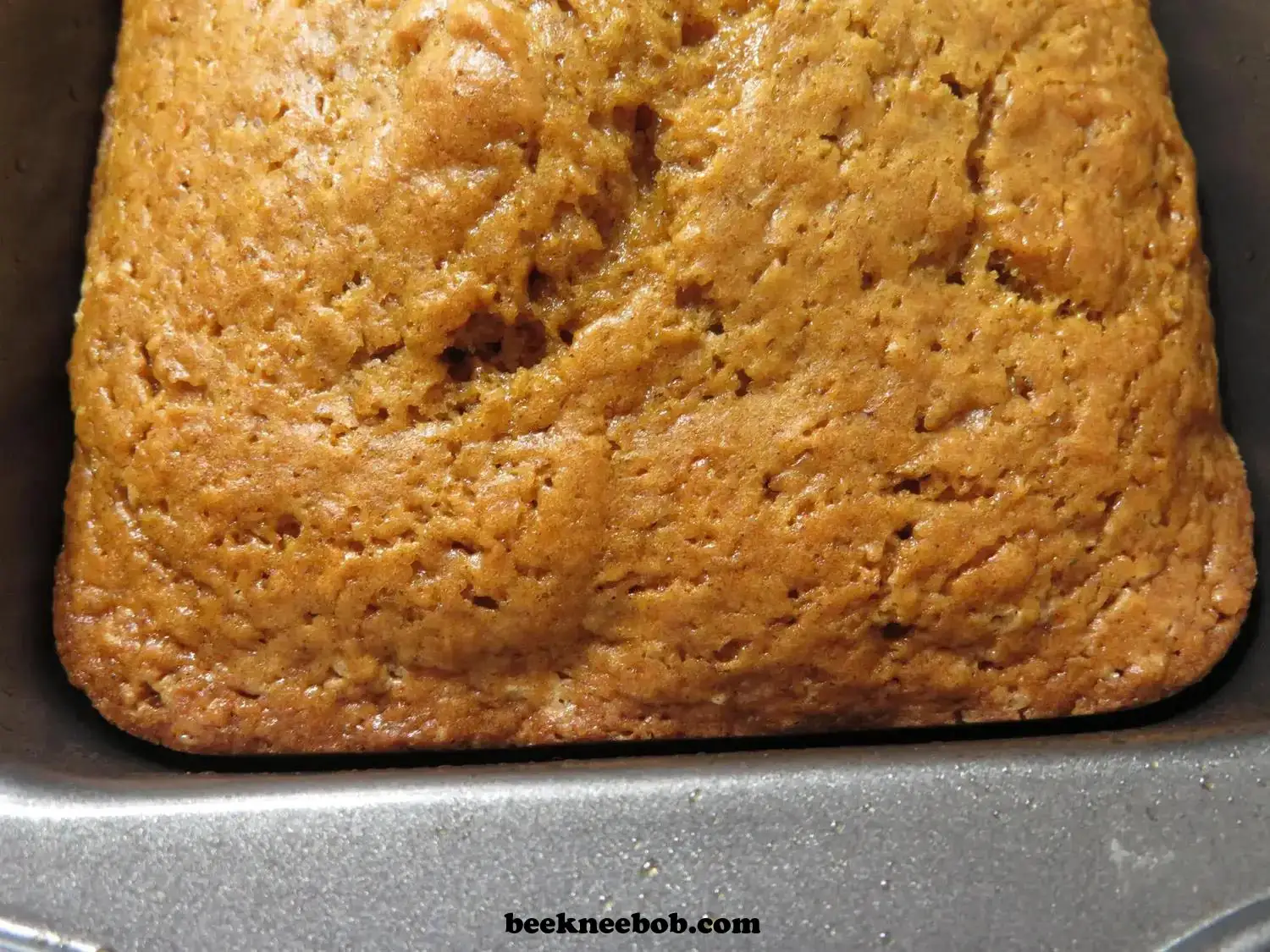 close up of baked pumpkin quick bread in loaf pan
