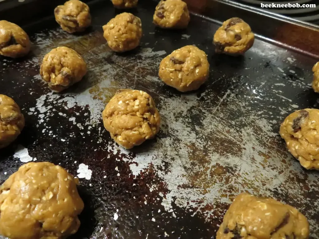 balls of oatmeal raisin cookie dough on baking sheet
