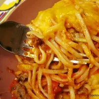 bowl of cheesy baked spaghetti with fork