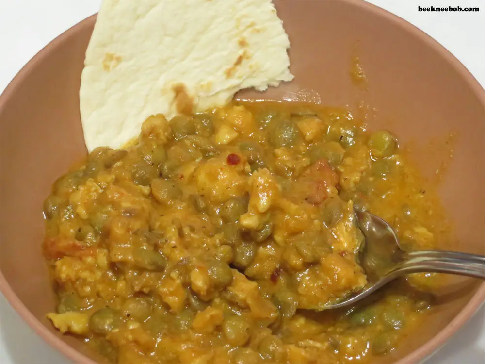 bowl of chicken lentil curry with bread