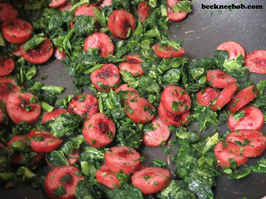 Browning smoked sausage and frozen spinach for a 4-ingredient creamy sausage and spinach pasta recipe.