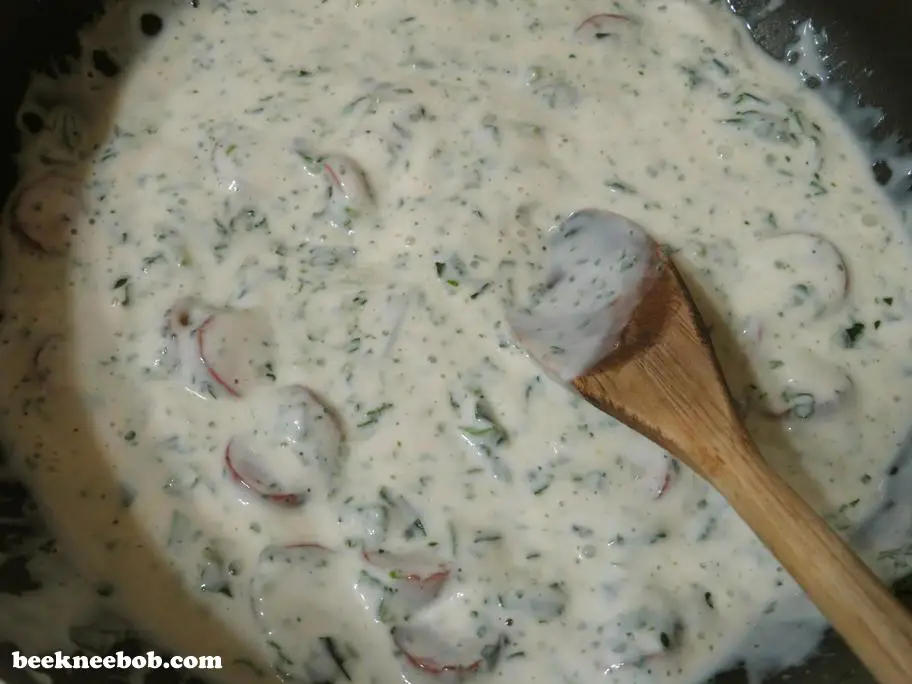 Preparing the creamy alfredo sauce with smoked sausage and spinach for 4-ingredient quick weeknight pasta.