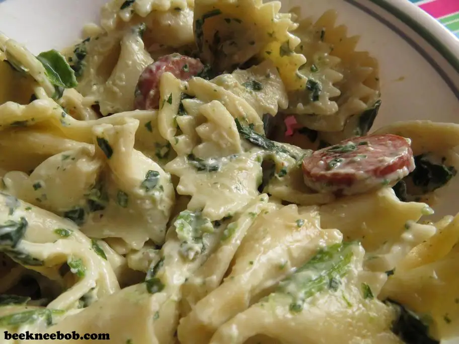 A warm bowl of sausage and spinach alfredo pasta ready for a 20-minute weeknight dinner.