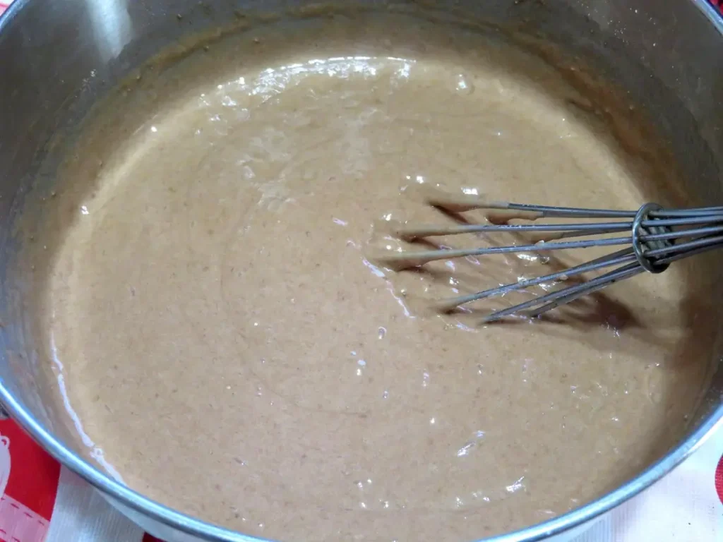 a bowl of whisked batter consisting of cherry cola soda and German chocolate cake mix