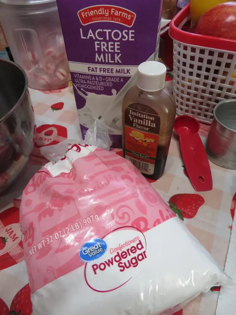 ingredients used for a simple cake glaze: powdered sugar, vanilla extract, and milk