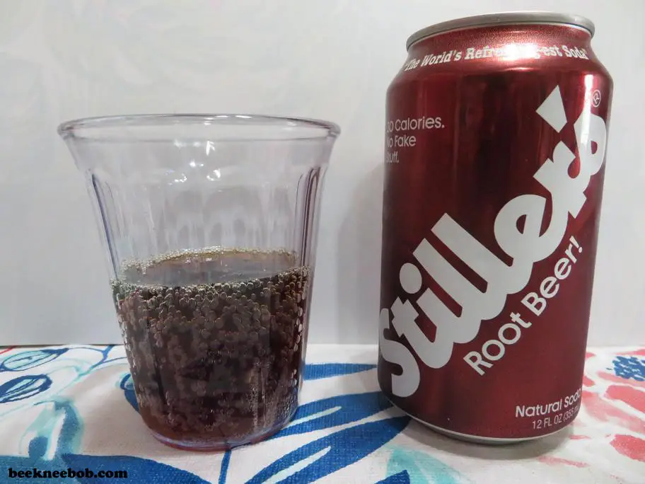 A cup containing Stiller's Root Beer Soda standing next to the soda can