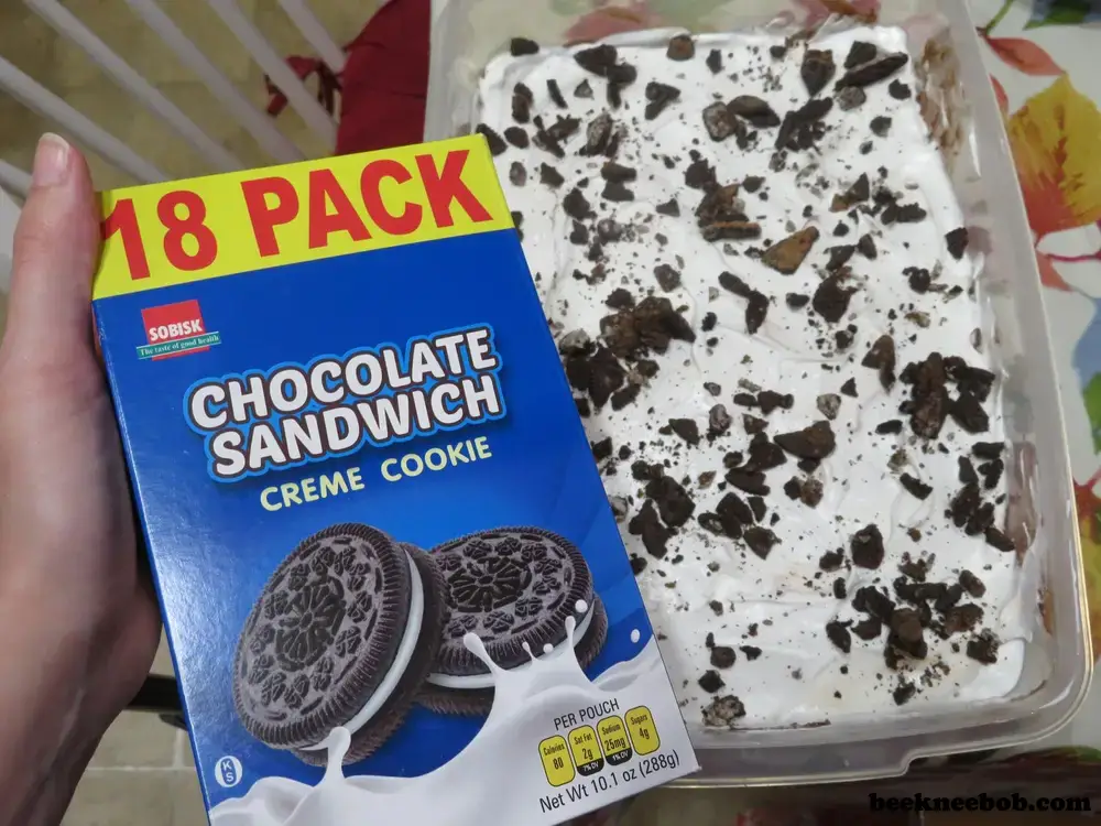 a box of Sobisk chocolate sandwich cookies held in front of a finished peanut butter cookie dirt pudding dessert