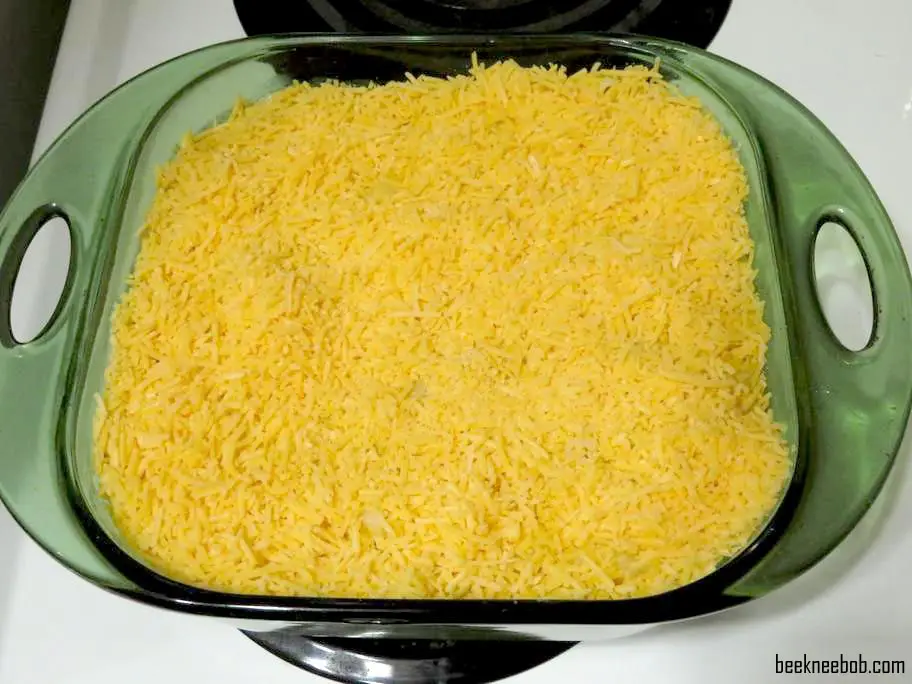 pre-baked layer of shredded sharp cheddar cheese on top of macaroni and cheese in a baking dish